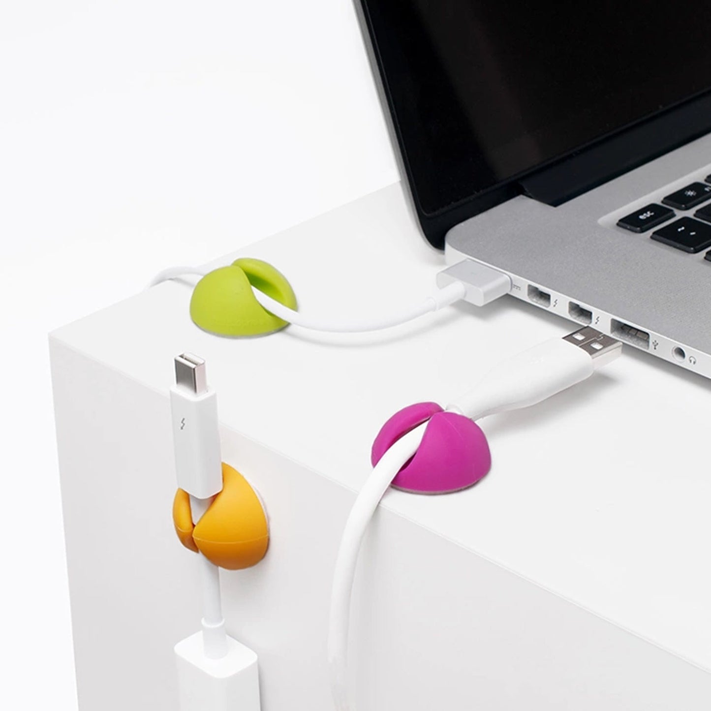 Cable organiser clips maintaining order for computer and mobile charging cables.