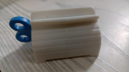 Toothpaste tube squeezer with its seat holder, emphasizing convenience and organization.